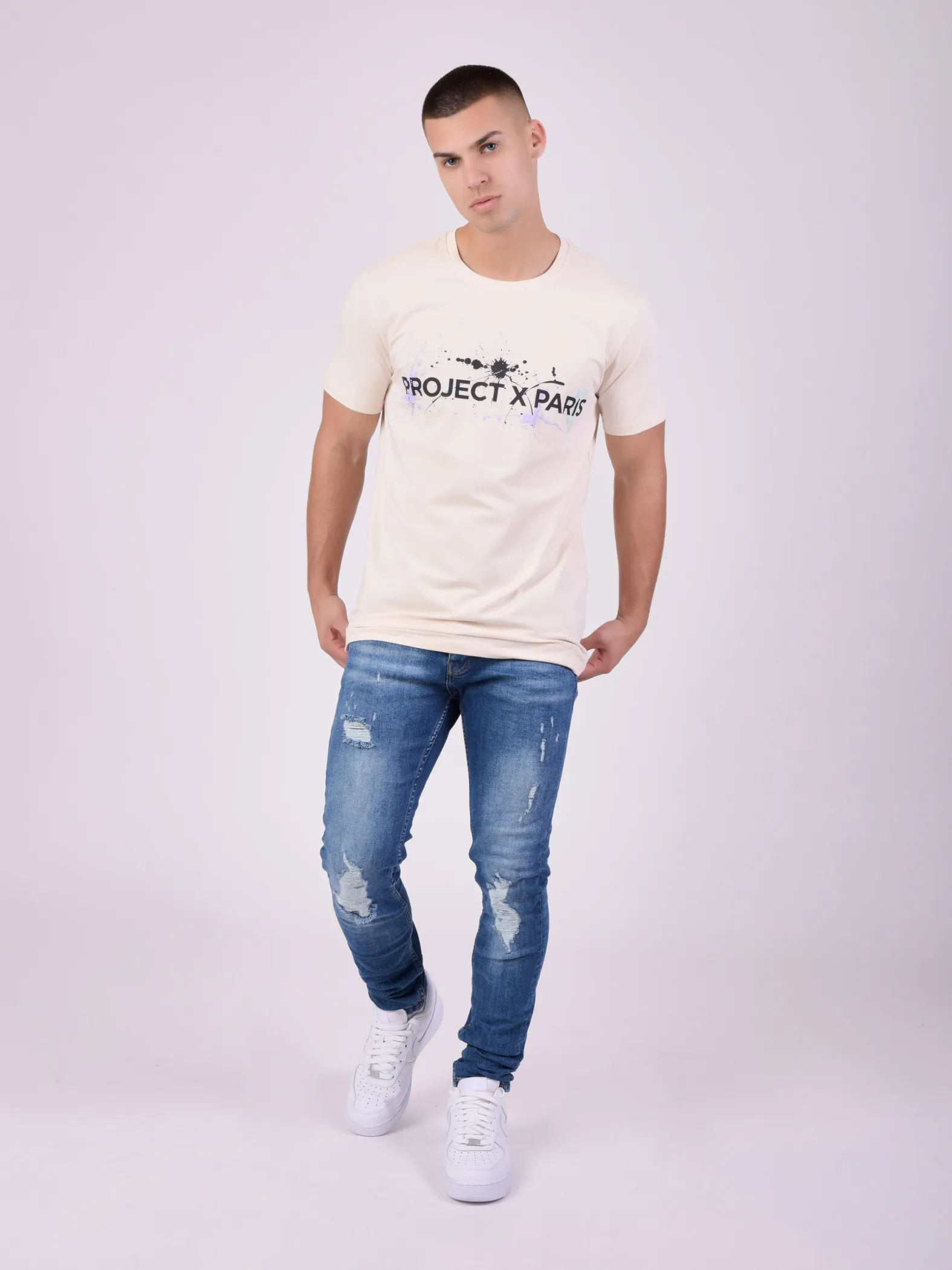 Camiseta de cuello redondo con logotipo y manchas de pintura estampados